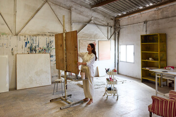 Artist creating a work in a spacious art studio setting