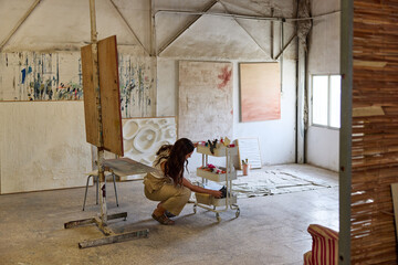 Artistic workspace with an artist organizing supplies in a studi