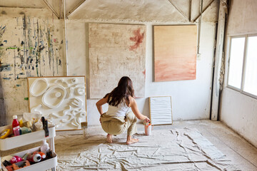 Artist at work in a bright studio creating abstract art