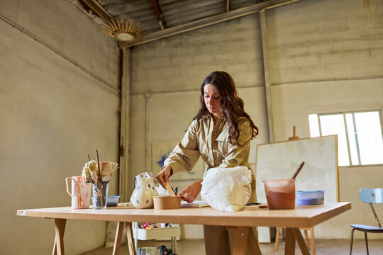 Creative woman working at a table in an art studio