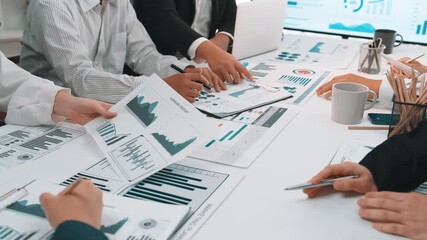A diverse group of professionals engage in a productive team meeting, analyzing data charts and graphs to enhance business strategies and inform financial planning. SACTR - Powered by Adobe