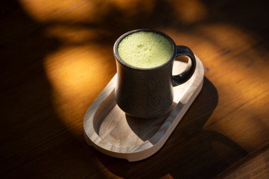 Matcha latte drink on sunlit table 