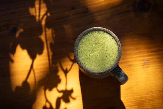 Matcha latte drink on sunlit table 