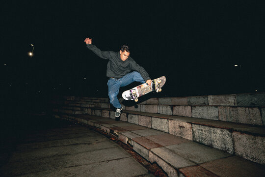 Skateboard Trick Over Rail at Night