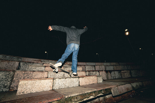 Skateboard Trick Over Rail at Night