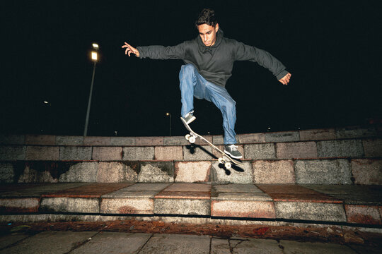 Skateboard Trick Over Rail at Night