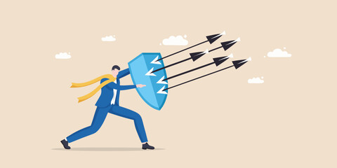 Businessman defends against incoming arrows with a shield