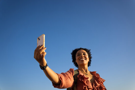 Woman Taking Selfie in Clear Blue Sky During Sunny Day