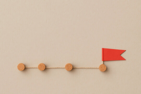 Strategic plan for achieving success often involves setting clear goals represented by markers along path. Each step signifies progress toward ultimate objective, symbolized by flag