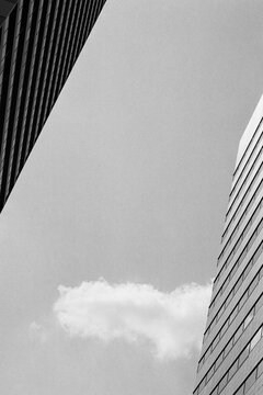 Urban skyscrapers framing sky and single cloud