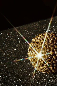 Shiny Golden Ball on Sparkling Surface With Bright Star Effect