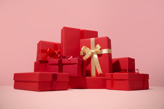 Red gift boxes with ribbons on a pink background