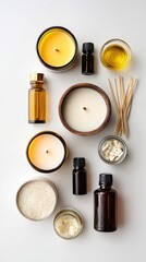 A flat lay of various candles, essential oils, and candle-making supplies arranged neatly on a light background.