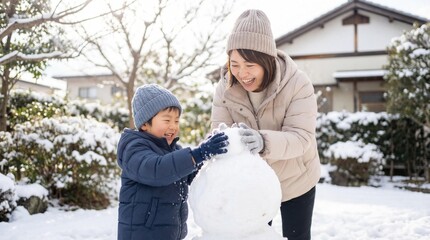 庭で雪だるまを作って遊ぶ笑顔の日本人親子