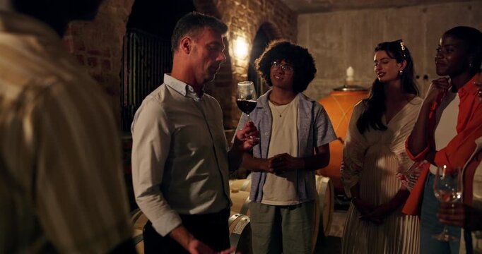 Sommelier, people and smell wine in cellar with glass for tasting experience, winemaking info and talk. Dark, winery owner and group with conversation for alcohol drink aroma, knowledge and advice.