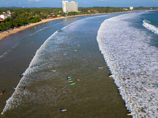 Aerial view of Weligama Beach with surfers riding the waves, Sri Lanka