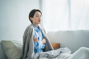 風邪をひき、寒さで震えている女性
