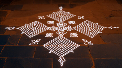 Pongal celebration intricate white kolam design with symmetrical geometric patterns on stone courtyard floor