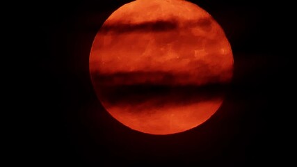 A short handheld ultra-zoom video shows a red-orange full moon as a dark cloud slices across its glowing surface, creating a striking night sky contrast, 2019 - Powered by Adobe