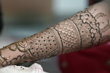Bengali bridal mehendi design being applied on woman&rsquo;s hand