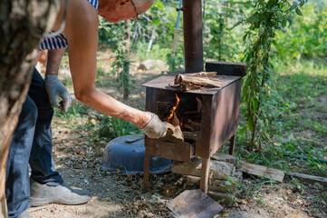 Grandfather teaching grandson to light outdoor stove, Grandfather and grandson preparing food on an outdoor stove in the backyard