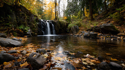 Autumn waterfall in a forest with colorful leaves and reflections