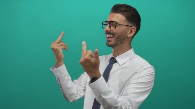 Hispanic man wearing white shirt and blue tie shows two middlefinger gestures in studio with teal backdrop; defiance.