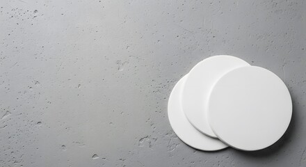 Two white oval shaped deodorant pads on a gray textured background