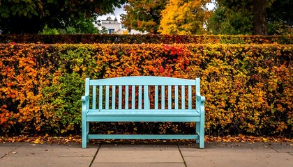 A serene blue bench in autumn park setting, inviting relaxation.