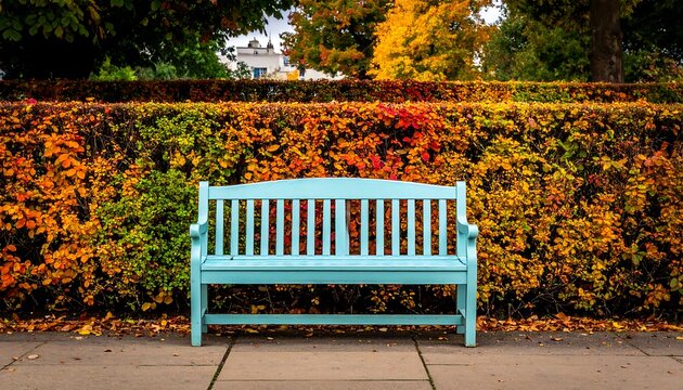 A serene blue bench in autumn park setting, inviting relaxation.