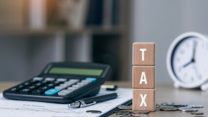 Wooden blocks showing tax 2026 on blue background. income tax form, coins, and financial documents on wooden desk, symbolizing budgeting, filing, and fiscal strategy
