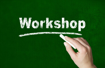 Person writing a Workshop word with chalk on a classroom style blackboard