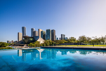 Stunning Urban Reflection: A Modern Cityscape Beneath Clear Blue Skies