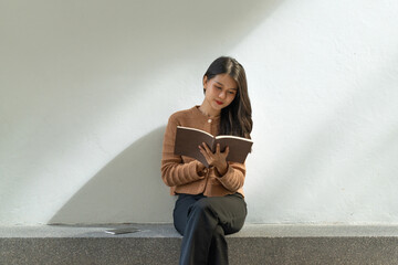 Beautiful Asian woman reading book in outdoor