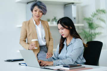 Fototapeta premium Asian senior businesswoman working with colleague working together