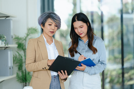 Asian senior businesswoman working with colleague working together
