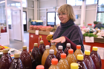 Woman shopping  bottles of juice at indoor market