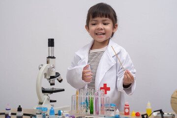 little girl in a lab coat experimenting with colorful test tubes and a microscope, representing science learning, curiosity, STEM education, childhood exploration, and creative scientific discovery.