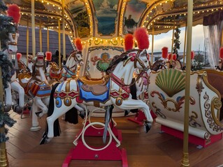 merry go round. Vintage Christmas carousel with painted horses and glowing lights at a winter fair. Festive amusement ride atmosphere. © Mariia