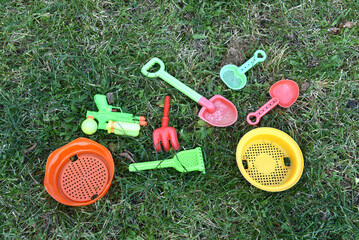 Colorful plastic sand toys on grass