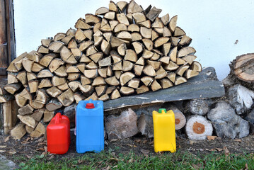 Stacked firewood and colorful plastic jerrycans