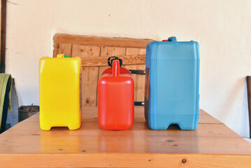 Collection of plastic jerrycans on a wooden table