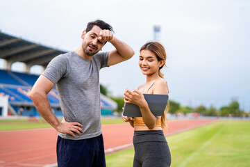 Caucasian young man athlete exercise with female trainer at the stadium. 