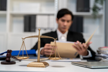 Asian lawyer working with gavel and scales of justice in courtroom office. 