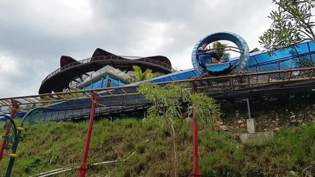 two kids play on sky ride at amusement park