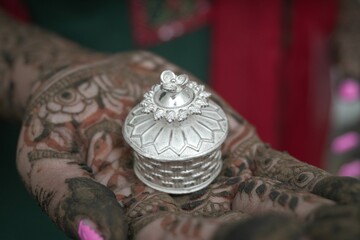 Bengali bridal mehendi hand holding traditional silver sindoor box