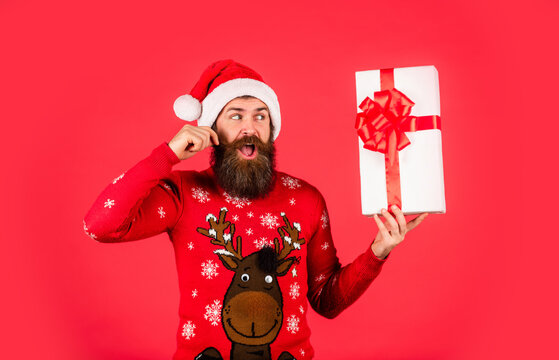 What a great surprise. ready for party celebration. morning before Xmas. bearded man in sweater. hipster enjoy the holiday. new year shopping idea concept. man in santa hat await christmas present