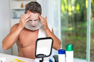 Collagen for glowing skin. Man with cloth moisturizing mask on face. Rejuvenating fabric mask...