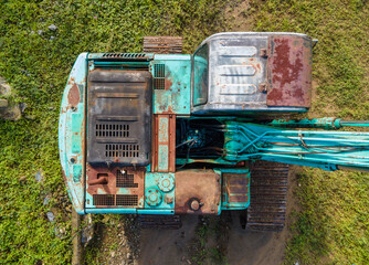 Excavator in green forest environment. Top view industrial machinery 