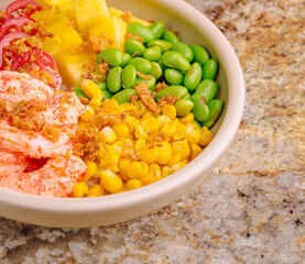 Colorful bowl of fresh vegetables and fruits on a granite countertop
